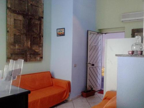 uma sala de estar com um sofá laranja e uma porta em B&B Acireale em Acireale