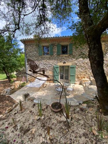 a stone house with a table and chairs in front of it at La Pause noble val in Saint-Antonin