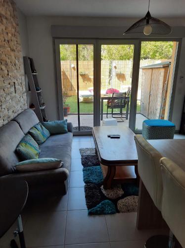 un salon avec un canapé et une table dans l'établissement Maison avec jardin, à Lunel