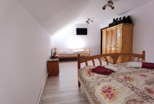 a bedroom with a bed and a dresser in a room at Casa David Vatra Moldoviței in Vatra Moldoviţei