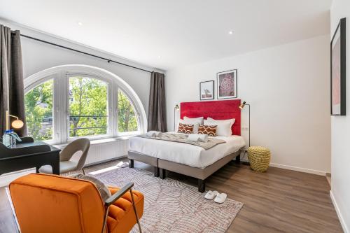 - une chambre avec un lit et une chaise orange dans l'établissement Sweett - Le Notre-Dame, à Paris