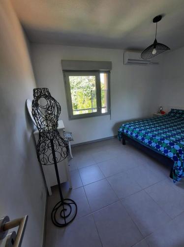 sypialnia z łóżkiem, krzesłem i oknem w obiekcie Maison avec jardin w mieście Lunel