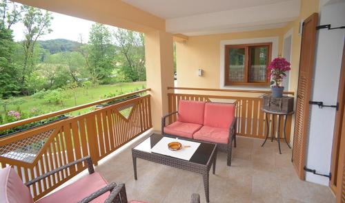 a balcony with pink chairs and a table with a view at Ferienwohnung Wruss in Gamlitz