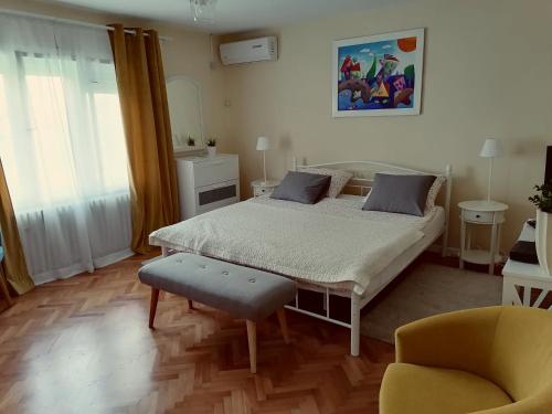 a bedroom with a large bed and a chair at Holiday Home Modric in Otočac
