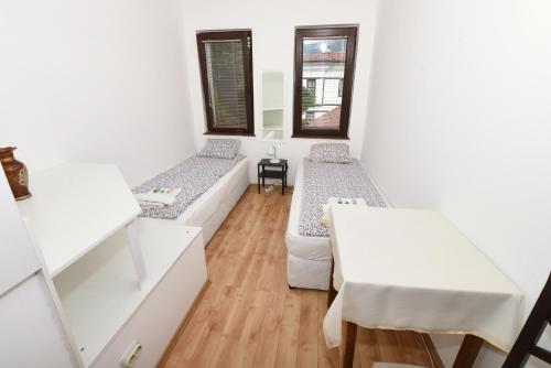 a room with two beds and a table at Jovanovic Guest House in Ohrid