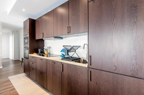 une cuisine avec des armoires en bois et un évier dans l'établissement Sweett - Le Notre-Dame, à Paris