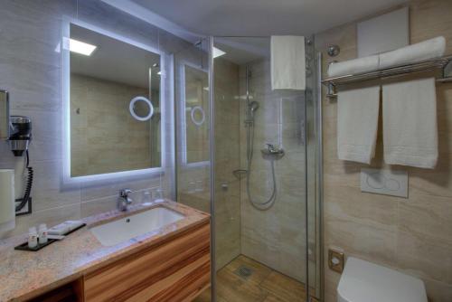 a bathroom with a toilet, sink and shower at Best Western Plus Hotel Füssen in Füssen
