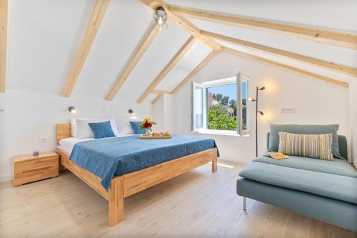 ein Schlafzimmer mit einem Bett und einer blauen Couch in der Unterkunft Seaside Cottage Maslina in Gdinj