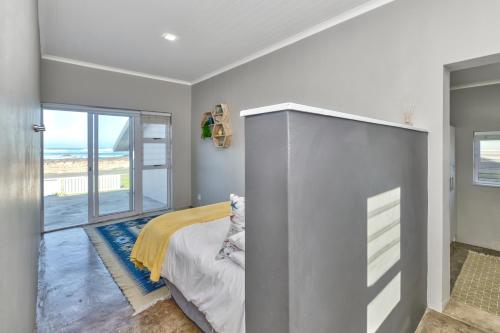 a bedroom with a bed and a view of the ocean at Klein Steenbok in Agulhas