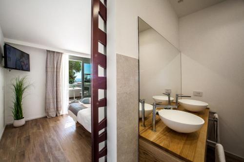 a bathroom with two sinks and a mirror at NOHA Lifestyle Hotel - Adults Only in Pula