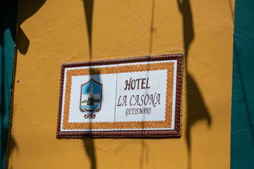 a sign on the side of a yellow wall at Hotel La Casona de Getsemani in Cartagena de Indias