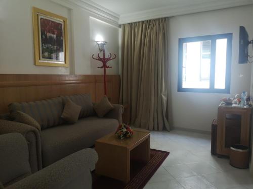 ein Wohnzimmer mit einem Sofa und einem Fenster in der Unterkunft Majliss Hotel Downtown in Rabat