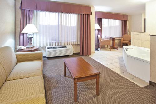 a living room with a couch and a table in a hotel room at Holiday Inn Express Hotel & Suites Barstow, an IHG Hotel in Barstow