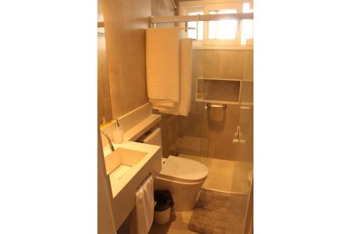 a small bathroom with a toilet and a sink at Casa d'Aroeira Residencial Boutique - Centro de Juqueí - 2 quadras do mar - Serviço de Praia - Roupa de Cama 600 fios algodão Egípcio - Toalhas Banho e Praia - Tudo Novo - Estacionamento Interno - Cozinha - Consulte unidades com Ofurô Hidro e Cromoterapia in Juquei