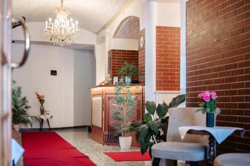 eine Lobby mit einem roten Teppich und einem Kronleuchter in der Unterkunft Landhotel Freitag in Sankt Paul im Lavanttal