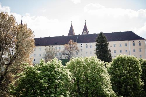 a large white building with trees in front of it at Landhotel Freitag in Sankt Paul im Lavanttal