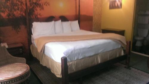 a bedroom with a large bed with white pillows at Branford Motel in Branford