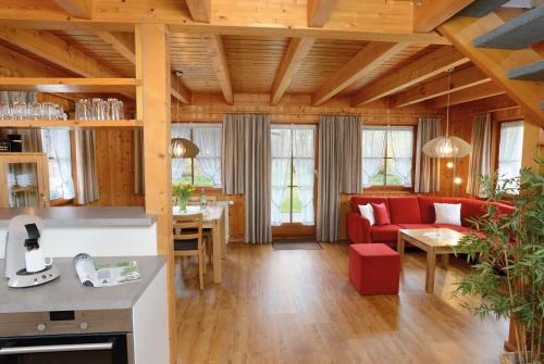 弗羅伊登施塔特的住宿－Landhaus Anja，客厅配有红色的沙发和桌子