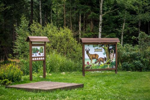two signs in the grass with animals on them at Drewniana Róża Domki Karkonosze in Piechowice