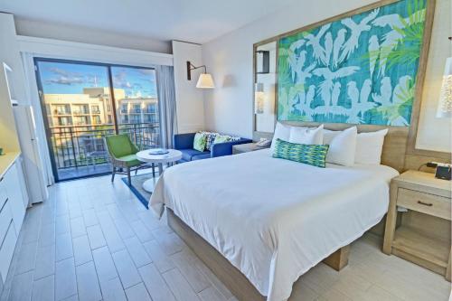 um quarto de hotel com uma cama grande e uma varanda em Margaritaville Vacation Club by Wyndham - Rio Mar em Río Grande