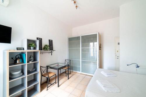 a room with a bed and a table and a glass cabinet at Hbhall Residenze Darsena in Milan