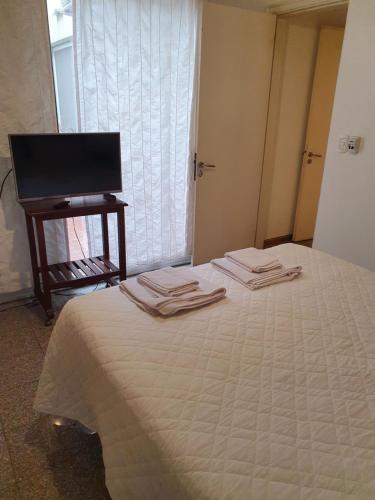 ロサリオにあるverdinegroのベッドとタオル2枚のある寝室