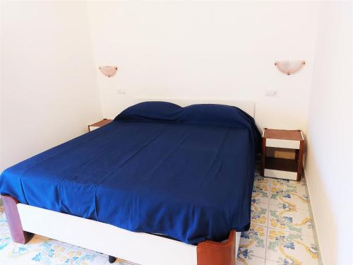 um quarto com uma cama com um cobertor azul em Luna blu em Erchie