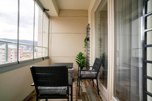 a balcony with two chairs and a table and windows at Apartman G8 Deluxe in Pale
