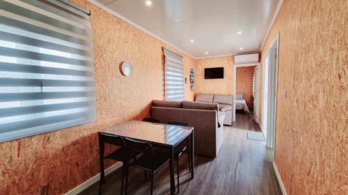 a living room with a couch and a table at Family Surf Home - Bungalow 5 in Ribamar