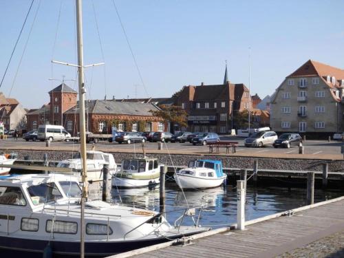 a group of boats docked at a dock at Det Gamle Hotel Rudkøbing in Rudkøbing