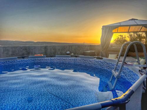 a swimming pool with a sunset in the background at Heaven In The Desert in Mitzpe Ramon