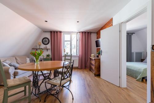 Apartamento pequeño con mesa y dormitorio en Kamienica Stare Miasto- Św . Ducha. en Elblag