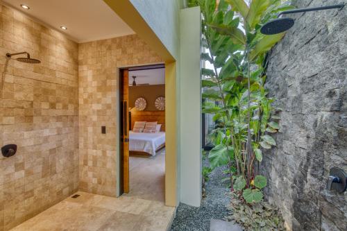a bathroom with a shower and a bedroom at Yoshi's on the beach in Cahuita