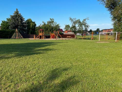 a large grassy field with a park with a playground at apartmán NA NOC V BOHDANČI in Lázně Bohdaneč