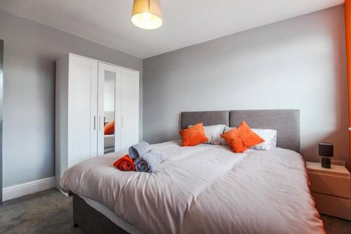 a bedroom with a large bed with orange pillows at PRIMEEE LOCATION - Modern Central Apartment in Bristol