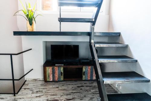 - un escalier en métal dans un salon avec une cheminée dans l'établissement Le Triplex les Halles intra muros, à Avignon