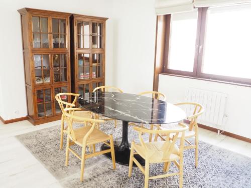 une salle à manger avec une table et des chaises noires dans l'établissement La suite de l'Observatoire, à Strasbourg