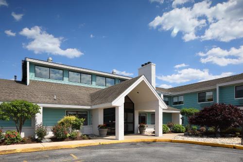 a house with a parking lot in front of it at Hotel Wave at Rehoboth Beach in Rehoboth Beach