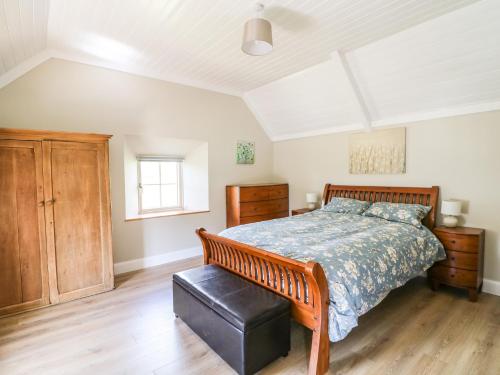 um quarto com uma cama grande e piso em madeira em Yew Tree House em Marley Bridge