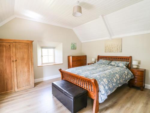 a bedroom with a large bed and a wooden floor at Yew Tree House in Marley Bridge