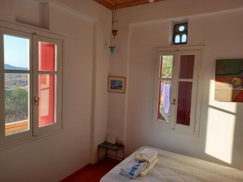 a bedroom with a bed and two windows at ArtHome0A in Panormos