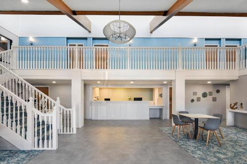 a lobby with a staircase and a table and chairs at Hotel Wave at Rehoboth Beach in Rehoboth Beach
