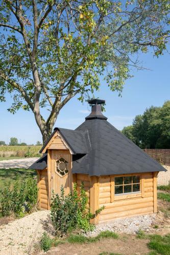 a small wooden dog house with a black roof at B&B Langeveldemolen in Merchtem