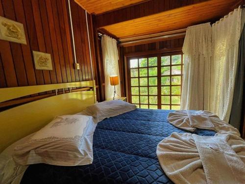 a bedroom with two beds and a window at Pousada Rural Vale Da Neblina in Urubici