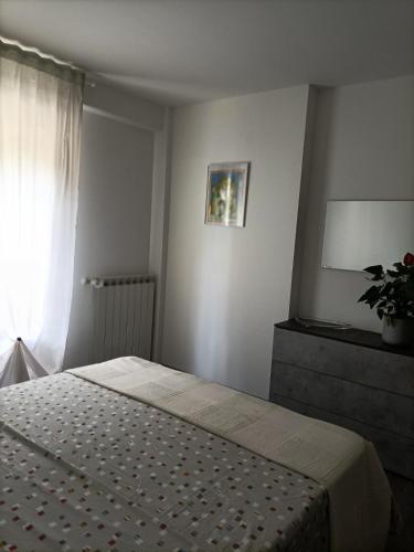 ein Schlafzimmer mit einem Bett und ein Fenster mit einer Pflanze in der Unterkunft apartment GiòHome in Grado