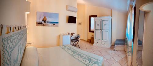 a bedroom with a bed and a table in a room at B&b Domo La Laguna in Càbras