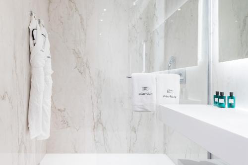 a white bathroom with a sink and a mirror at Villas Foch Boutique Hotel & Spa Bordeaux in Bordeaux