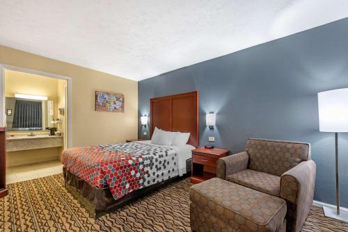 een hotelkamer met een bed en een stoel bij Econo Lodge in Erlanger