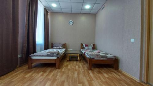 a room with two twin beds and a window at Отель Меридиан in Zolotonosha