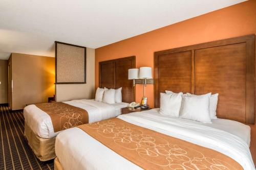 two beds in a hotel room with orange walls at Comfort Suites in Panama City Beach